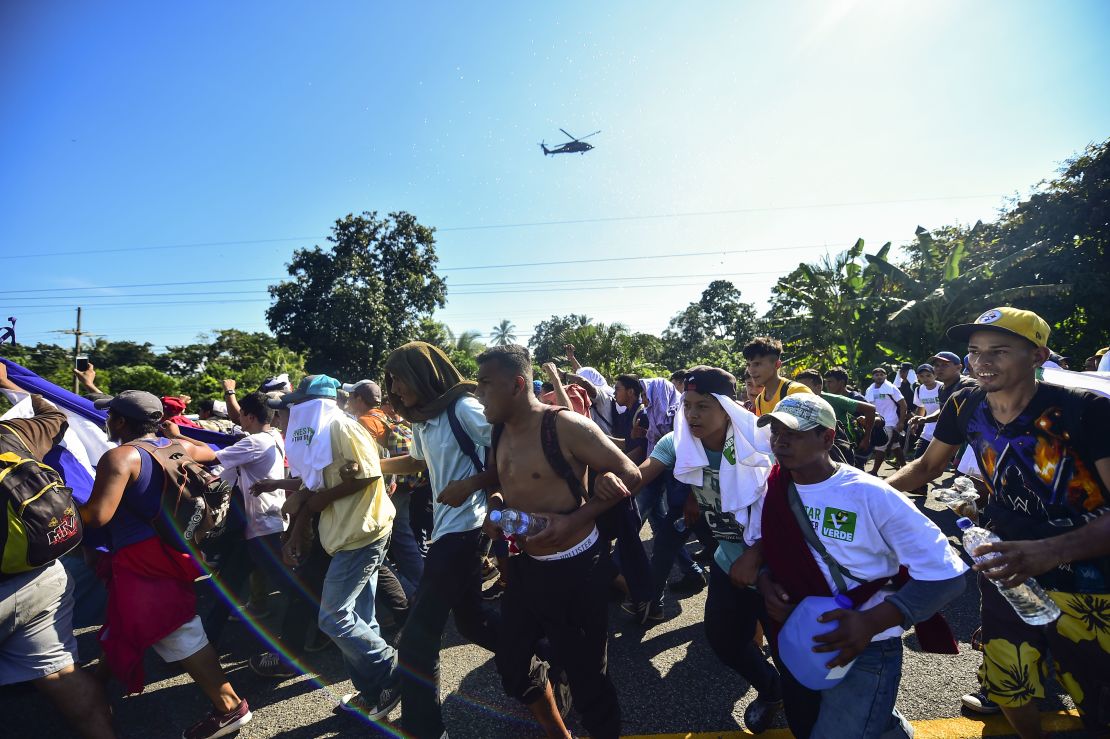 Un helicóptero de la Policía Federal de México sobrevuela la caravana de migrantes.