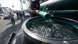 Employees of Mexico City's Water System fill a tank with drinking water during a running water cut off due to maintenance tasks in Mexico City on October 31, 2018. - Officials announced a cut off of four days starting Wednesday due to major maintenance operations. (Photo by ALFREDO ESTRELLA / AFP)