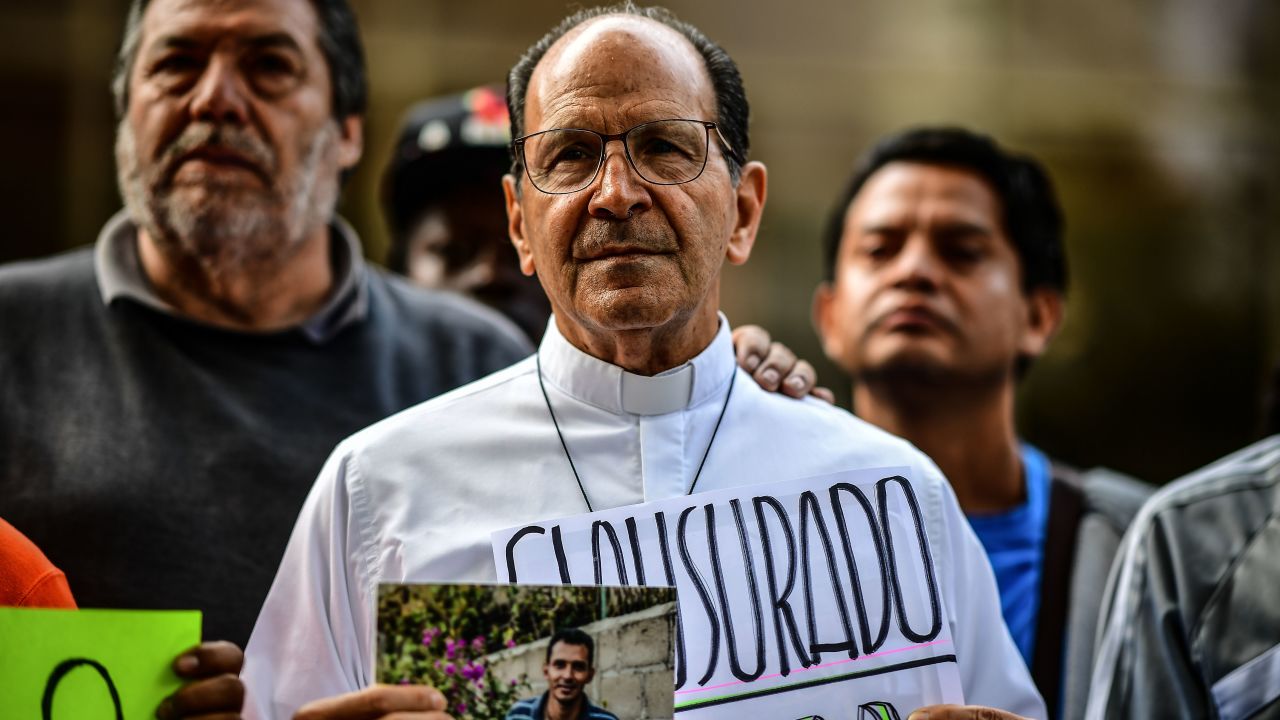 Catholic priest and Human Rights activist Alejandro Solalinde (C) heads a protest, along with migrants and other activists, at the National Institute of Migration, in Mexico City, on September 25, 2018. - Solalinde, a defender of migrants' rights, called for a symbolic closure of Mexico's National Migration Institute, after the repression against migrants on September 9 in the State of Veracruz. (Photo by RONALDO SCHEMIDT / AFP)