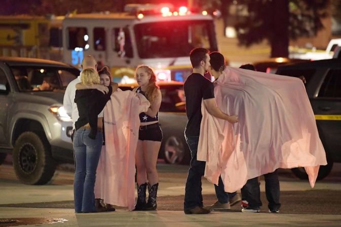 Personas se abrazan cerca del lugar del tiroteo en Thousand Oaks, Californina, en la madrugada del jueves.