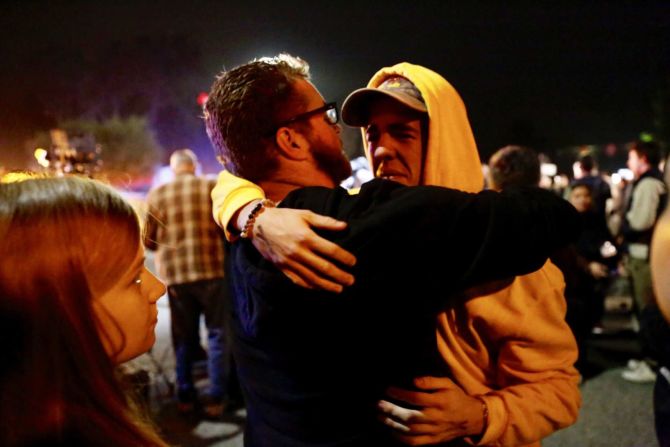 Holden Harrah, de 21 años, a la derecha, abraza a familiares y amigos después de presenciar la matanza.