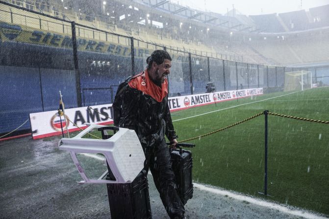 Un fotógrafo se alistaba para trabajar bajo una intensa lluvia en el estadio La Bombonera, antes del partido de fútbol de ida por la final de la Copa Libertadores 2018.  / AFP / Getty Images)