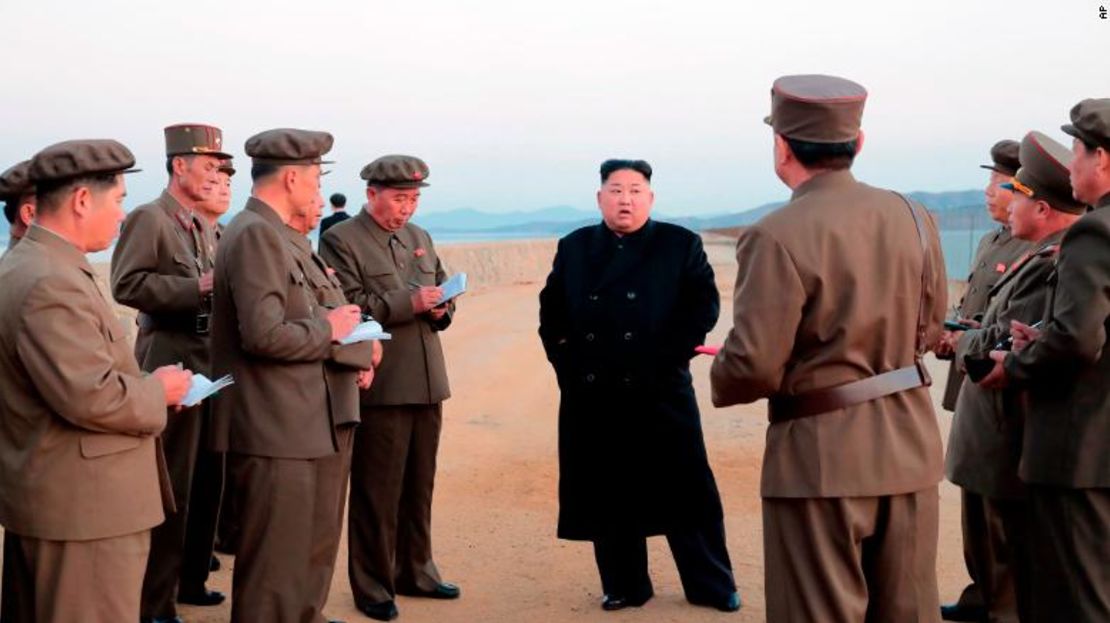 En esta foto sin fecha dada a conocer el viernes por el gobierno norcoreano, Kim Jong Un escucha a un funcionario militar mientras acude a una prueba de armamento.