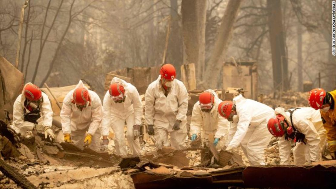 Vestidos con monos blancos, integrantes de los cuerpos de rescate buscan cuerpos de víctimas de los incendios en California.