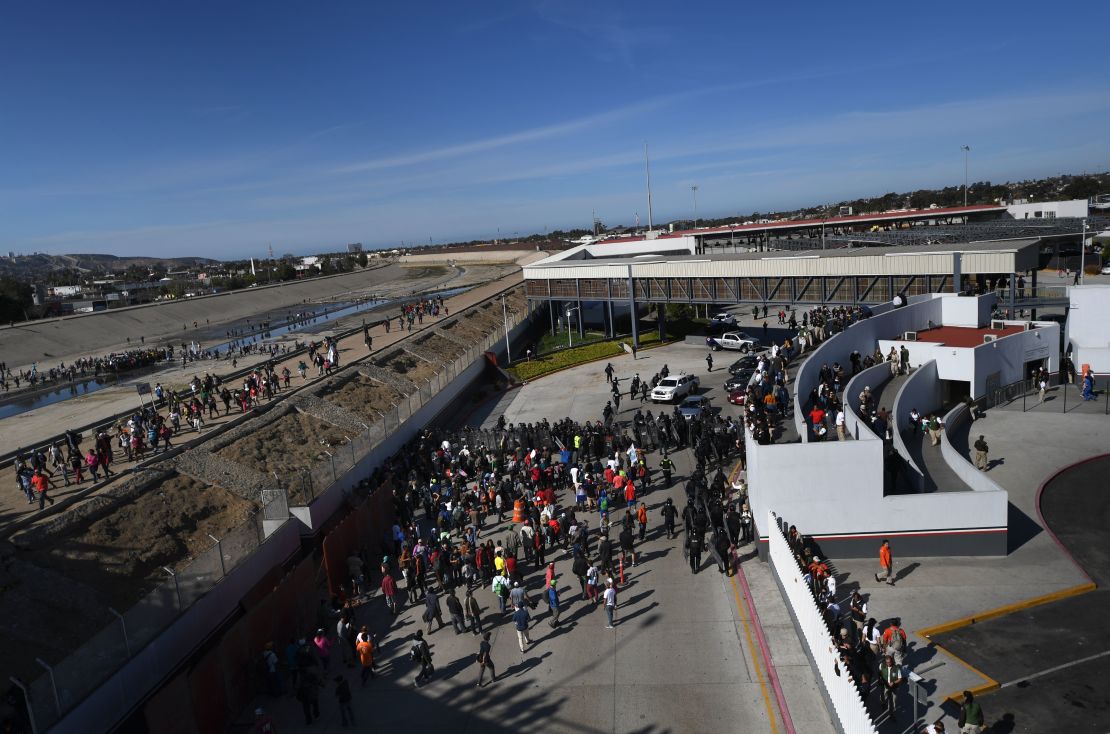 Un grupo de migrantes centroamericanos, principalmente de Honduras, llega al puerto de entrada de El Chaparral después de cruzar el cauce casi seco del río Tijuana, en Tijuana, estado de Baja California, México.