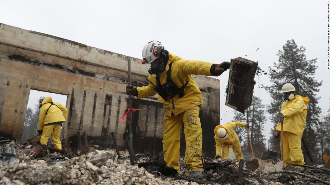 Brigadas de bomberos buscan entre los restos de una zona arrasada por el incendio Camp.