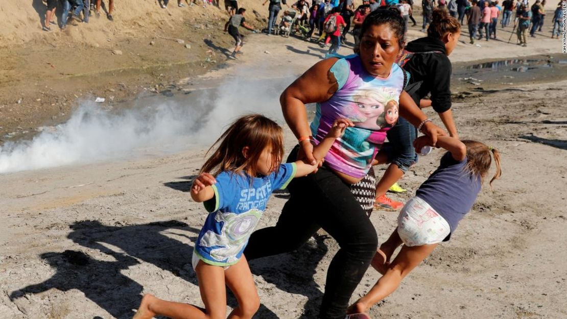 Una mujer y unas niñas se alejan de los gases lacrimógenos lanzados en la frontera entre México y Estados Unidos.