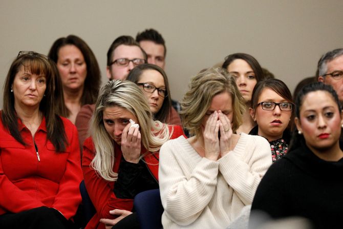 La gente reacciona en un tribunal de Lansing, Michigan, cuando Rachael Denhollander, que no aparece en la foto, habla durante la audiencia de sentencia de Larry Nassar, ex médico del equipo de Gimnasia de EE.UU. y la Universidad Estatal de Michigan. Nassar se declaró culpable de siete cargos de conducta sexual delictiva y admitió haber agredido y abusado sexualmente de niñas con el pretexto de proporcionar tratamiento médico. Denhollander, una ex gimnasta, fue la última de las más de 150 mujeres y niñas que lo enfrentaron en la corte durante su audiencia de sentencia. La juez de la Corte de Circuito Rosemarie Aquilina le dio a Nassar una sentencia de prisión de 40 a 175 años.