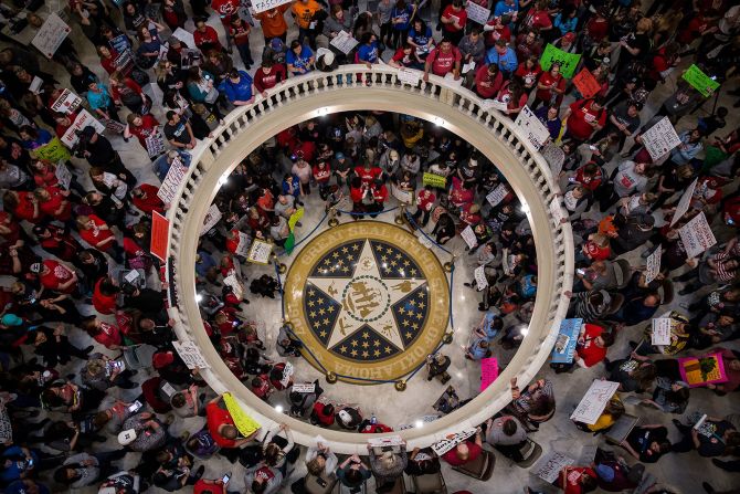 3 de abril — Manifestantes sostienen carteles durante un mitín dentro del edificio del Capitolio Estatal de Oklahoma. Cientos de maestros llenaron el Capitolio esa semana, exigiendo 150 millones de dólares adicionales en financiación escolar y mayores aumentos salariales para ellos y para el personal de apoyo. Terminaron su huelga después de nueve días cuando "no hubo un movimiento legislativo significativo", según Alicia Priest, presidenta del sindicato de maestros más grande del estado. Los maestros ya habían recibido aumentos antes de que comenzara la huelga, pero el sindicato dijo que no eran suficientes.