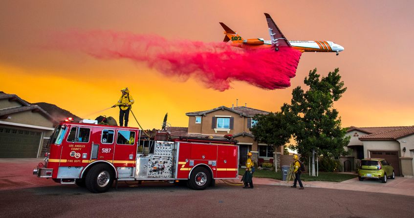 8 de agosto - Un avión deja caer retardante contra fuegos detrás de las casas mientras el “Fuego Santo” arde en Lake Elsinore, California. Más de 14.000 bomberos combatieron los incendios forestales que devastaron partes del estado ese mes (Mark Rightmire / The Orange County Register / AP).