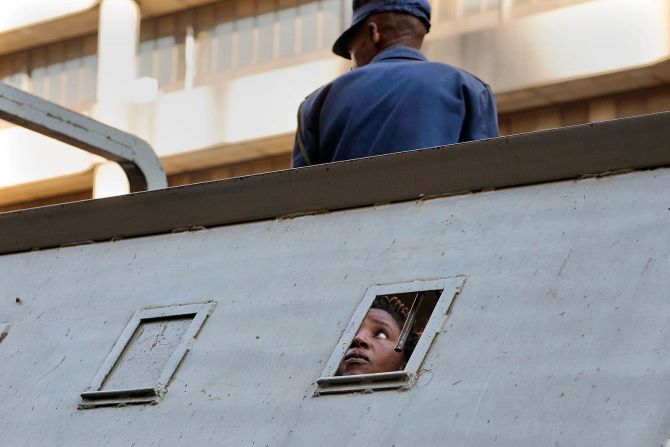 2 de agosto - Un partidario del principal partido de la oposición de Zimbabwe, el Movimiento para el Cambio Democrático, mira desde un vehículo policial luego de ser detenido fuera de la sede del MDC en el pueblo de Harare. El lugar parecía un pueblo fantasma ese día, menos de 24 horas después de que las fuerzas de seguridad y los manifestantes de la oposición se enfrentaran por los resultados de las elecciones del país (Jerome Delay / AP).