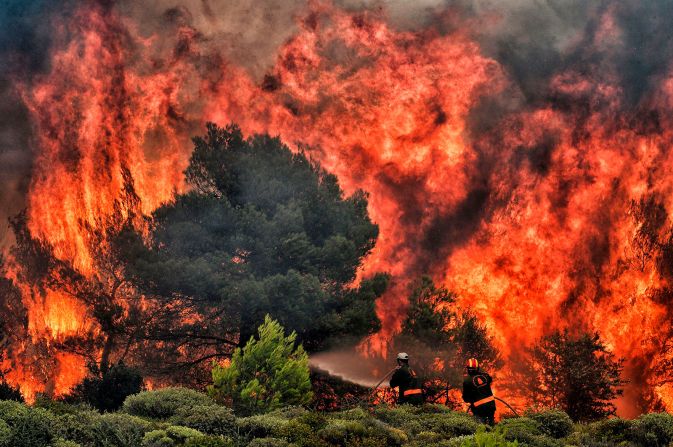 24 de julio - Los bomberos intentan extinguir las llamas de los incendios forestales en Kineta, Grecia. Decenas de personas murieron en los incendios forestales, los peores en afectar a Grecia en más de una década (Valerie Gache / AFP / Getty Images).