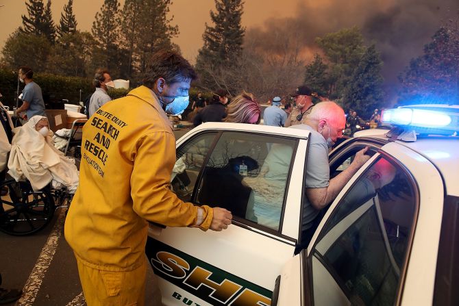 8 de noviembre - los trabajadores del hospital y el personal de primeros auxilios evacuan el hospital Feather River mientras se quema el incendio Camp en Paradise, California. Los fuertes incendios forestales en California destruyeron un número récord de edificios y desplazaron más de 300.000 personas. El incendio Camp se convirtió en el incendio forestal más destructivo de la historia de California, y el más mortal. Justin Sullivan / Getty Images