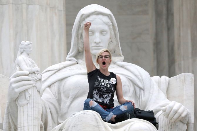 6 de octubre - una manifestante se sienta en el regazo de la Dama Justicia (Lady Justice) fuera del edificio de la Corte Suprema de EE.UU. Hubo mítines en todo el país donde la gente expresó su oposición a la confirmación del candidato a la Corte Suprema Brett Kavanaugh. Jonathan Ernst / Reuters