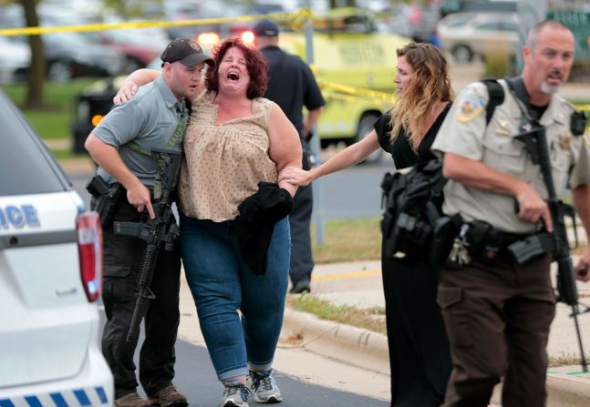 19 de septiembre - escoltan a una mujer del lugar de un tiroteo en Middleton, Wisconsin. Tres personas resultaron gravemente heridas cuando un compañero de trabajo abrió fuego contra una empresa de software, dijo la policía. El pistolero recibió disparos de la policía y más tarde murió en el hospital. Steve Apps / Wisconsin State Journal / AP