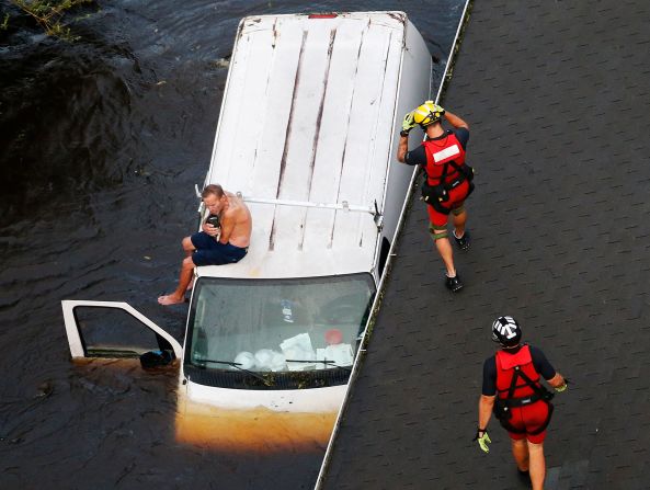 17 de septiembre - Willie Schubert acuna a su perro, Lucky, sobre una camioneta varada mientras esperan la ayuda de la Guardia Costera de Estados Unidos en Pollocksville, Carolina del Norte. La ciudad fue inundada por el huracán Florence. Steve Helber / AP