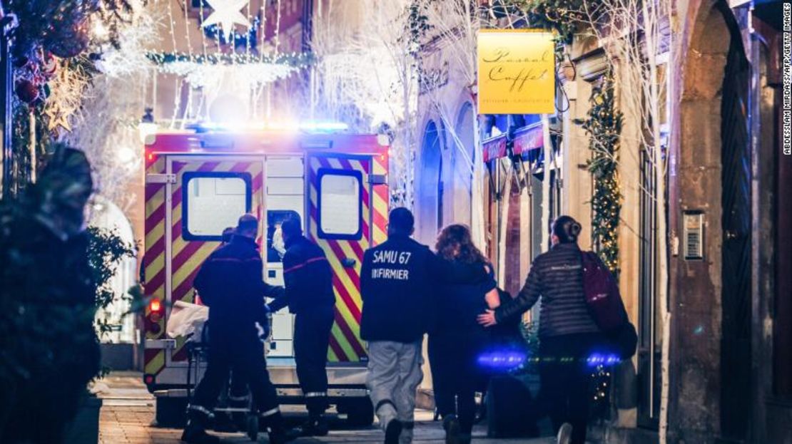 Equipos de emergencia escoltan a una mujer después del tiroteo en Estrasburgo el martes.