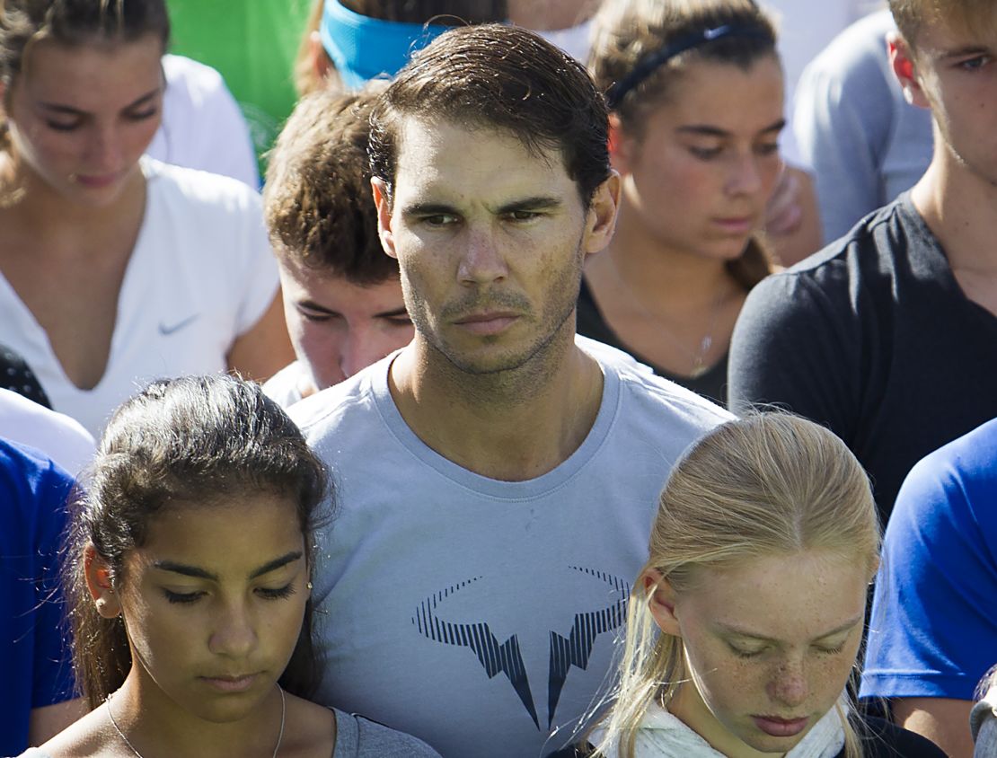 El tenista español Rafa Nadal participa en un minuto de silencio el 11 de octubre de 2018, con estudiantes y trabajadores de la "Academia Rafa Nadal" en Manacor, para honrar a las víctimas de la inundación que afectó a la isla balear española de Mallorca.