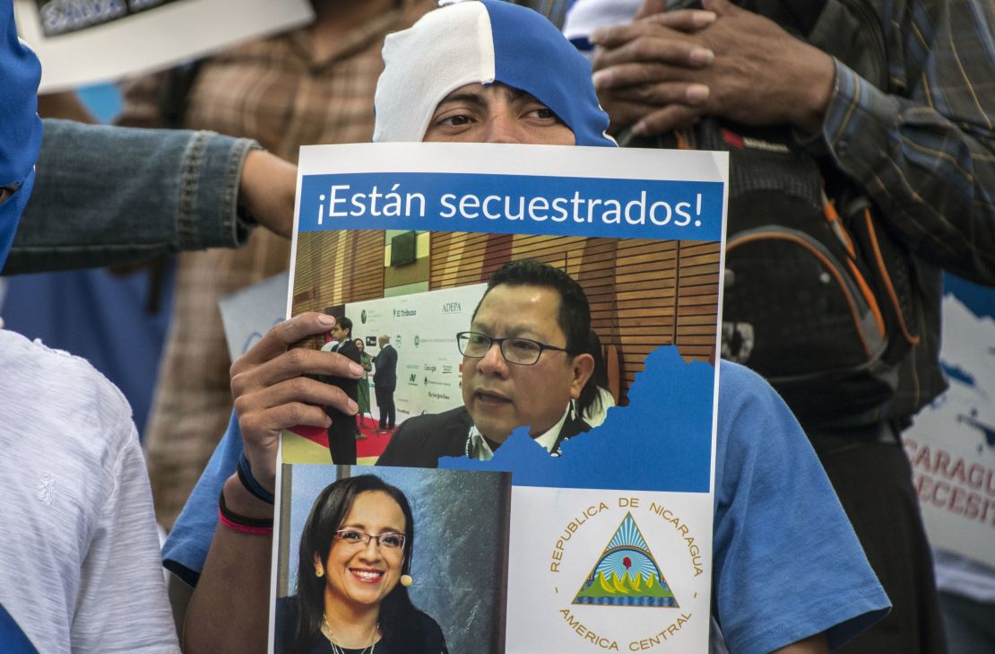 Un nicaragüense sostiene una pancarta con los retratos de los periodistas de la oposición arrestados Miguel Mora y Lucía Pineda con una leyenda que dice "Están secuestrados", durante una manifestación frente a la embajada de Nicaragua en San José, Costa Rica, el 22 de diciembre.