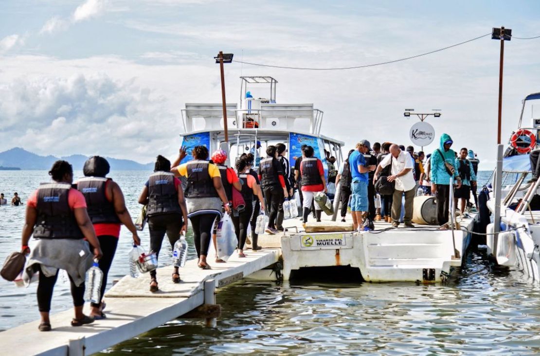 Migrantes varados, en su mayoría de Venezuela, se suben a un bote en la ciudad portuaria colombiana de Necoclí, para cruzar a la vecina Panamá y continuar su viaje hacia los Estados Unidos, el 11 de octubre de 2022. - Miles de migrantes con destino a los Estados Unidos, en su mayoría de Venezuela , permanecen varados en Necoclí mientras esperan que los barcos los crucen hacia la vecina Panamá para continuar su peligroso viaje hacia el norte.