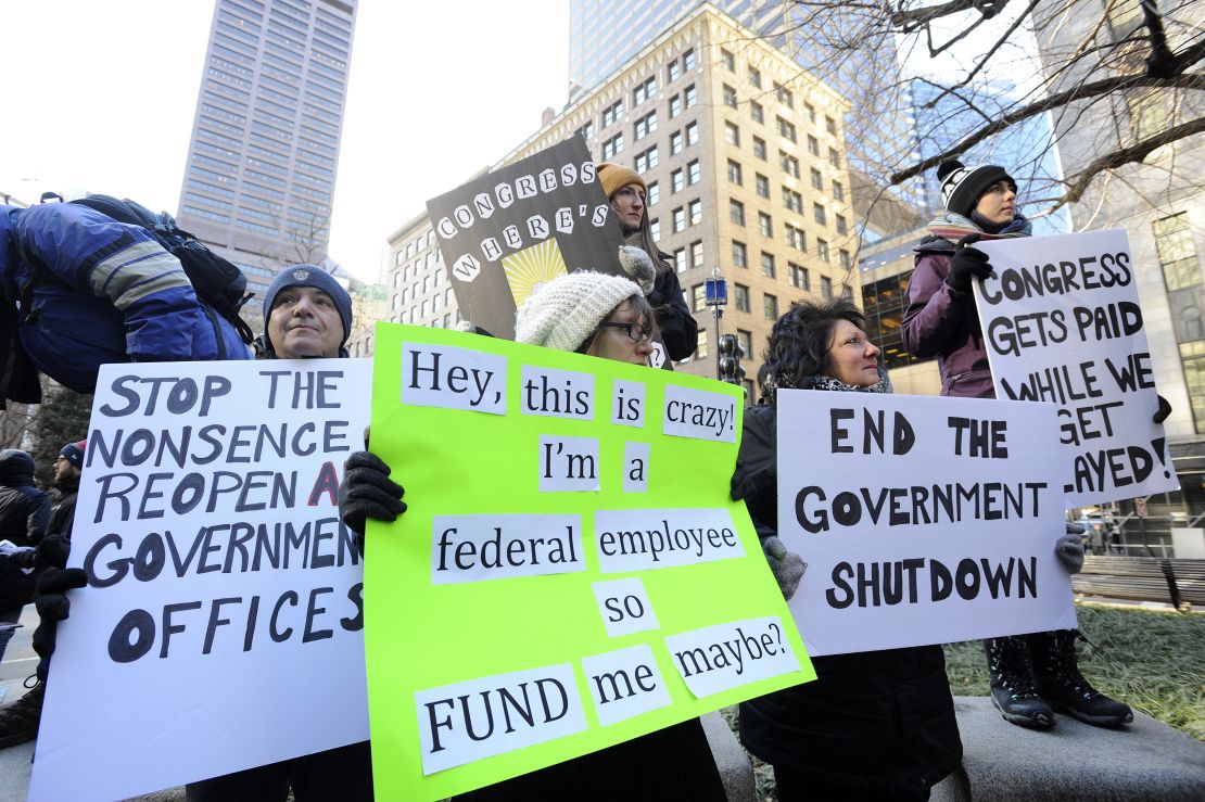 Manifestantes sostienen carteles durante una protesta de ciudadanos preocupados por el cierre del Gobierno de Estados Unidos en Boston.