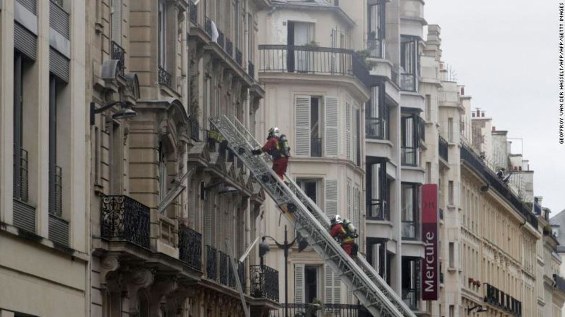 Equipos de bomberos ayudando a las personas en las viviendas que rodean la panadería.