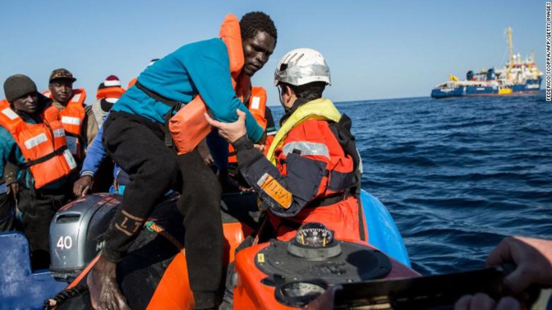 Un grupo de 47 inmigrantes es transferido de un bote inflable a un barco de rescate.