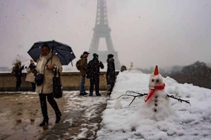 Un muñeco de nieve con la Torre Eiffel de fondo.