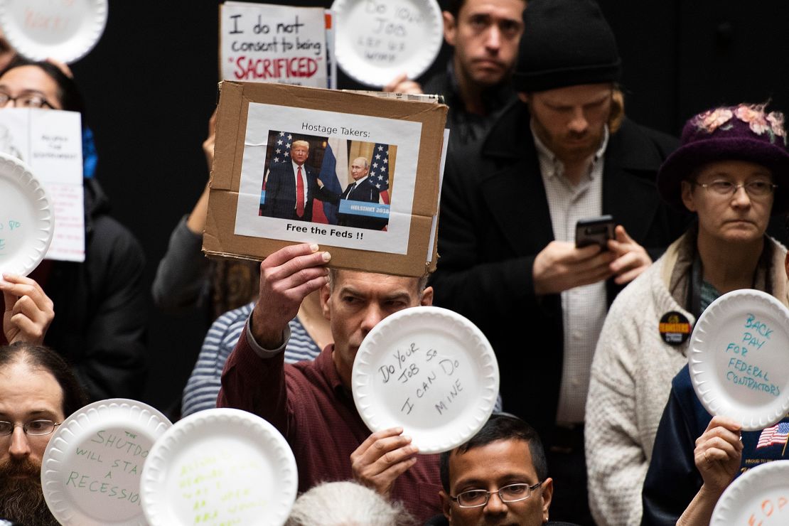 Empleados federales sostienen platos vacíos en una protesta, en Washington.