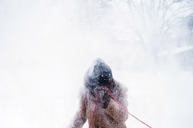 Sarah Allen queda cubierta en nieve mientras despeja su camino de entrada y aceras con un soplador de nieve en Flint, Michigan.