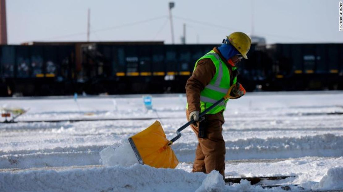 Un trabajador quita la nieve de las vías de trenes.