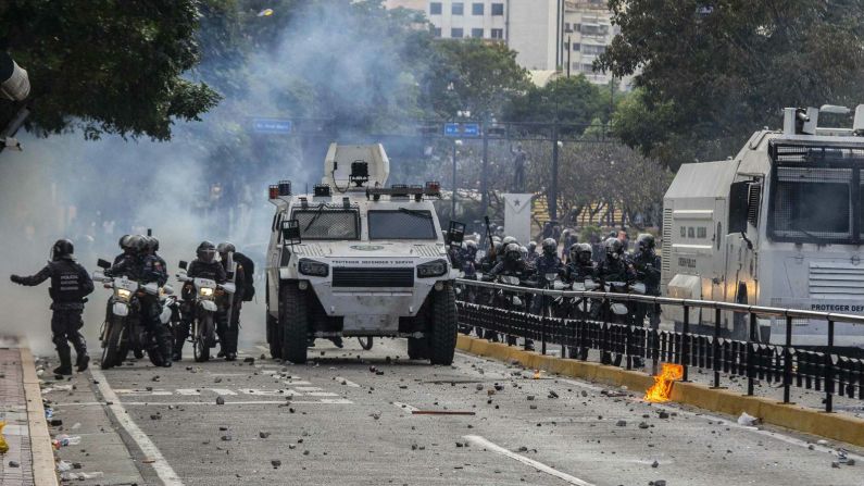 Fuerzas de seguridad se paran en una calle llena de piedras tras enfrentarse con manifestantes en Caracas. (Rayner Pena / alianza fotográfica a través de Getty Images).