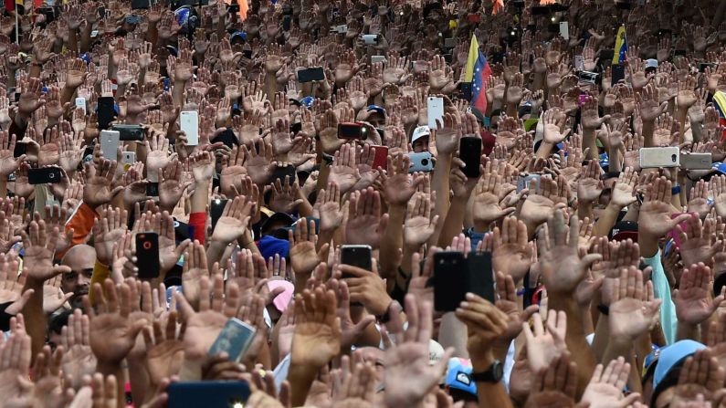 Los asistentes a la marcha del 23 de enero levantaron sus manos para mostrar solidaridad con Guaidó, que se autoproclamaba presidente interino ese día. (Féderico Parra / AFP / Getty Images).