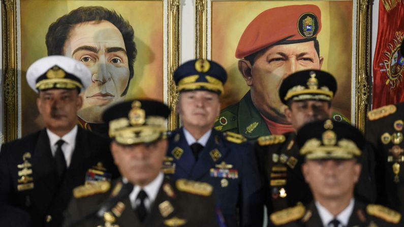 Retratos de los exlíderes venezolanos Simón Bolívar y Hugo Chávez se ven detrás del ministro de Defensa de Venezuela, Vladimir Padrino López, abajo a la izquierda, que da una conferencia de prensa en Caracas el 24 de enero de 2019. Los altos oficiales militares venezolanos juraron lealtad a Maduro después de que otros países reconocieran a Guaidó como jefe de Estado. (Carlos Becerra / Bloomberg via Getty Images).