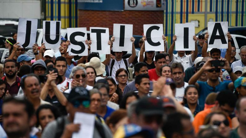 Partidarios de la oposición venezolana sostienen carteles que dicen "Justicia" en una concentración para escuchar hablar a Juan Guaidó en Caracas el 26 de enero de 2019. (Féderico Parra / AFP / Getty Images).