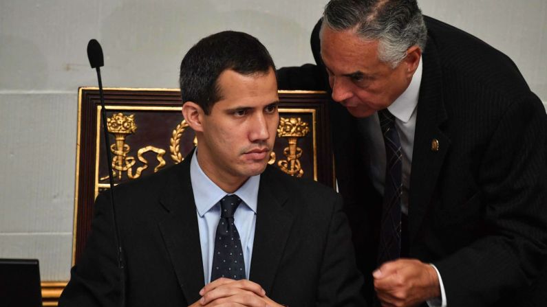 El presidente de la Asamblea Nacional y autoproclamado presidente interino Juan Guaidó, a la izquierda, escucha al diputado Rafael Veloz durante una sesión en la Asamblea Nacional en Caracas, el 29 de enero. La Asamblea se reunió para debatir un marco legal para crear un gobierno de transición y convocar nuevas elecciones. Simultáneamente, el fiscal general de Venezuela le pidió a la Corte Suprema que congele los bienes de Guaidó y le prohibió abandonar el país. (Yuri Cortés / AFP / Getty Images).