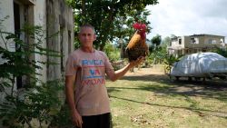 Eduardo Caban poses with his rooster named Coco which he rescued from drowning after the garage the bird was in started to flood during the passing of Hurricane Maria six months after the storm affected the island in Fajardo, Puerto Rico on March 17, 2018.
Six months after Hurricane Maria hit the island on September 20, 2017 uprooting trees, destroying homes, and causing widespread flooding, many remain without power. / AFP PHOTO / Ricardo ARDUENGO