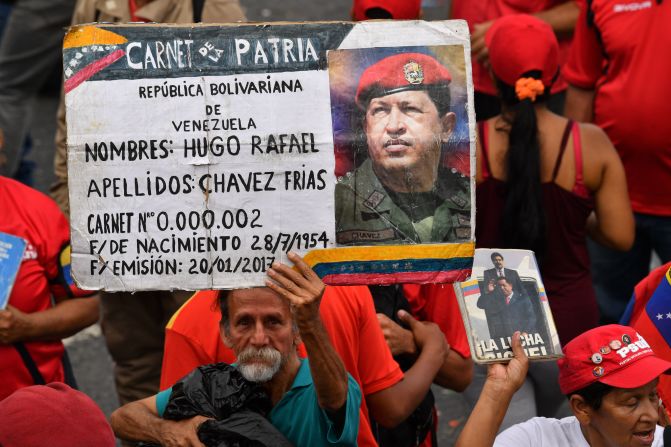 Un simpatizante del presidente venezolano Nicolás Maduro muestra un cartel con una foto del fallecido presidente Hugo Chávez, durante una reunión para conmemorar el vigésimo aniversario del ascenso del poder del difunto Chávez.