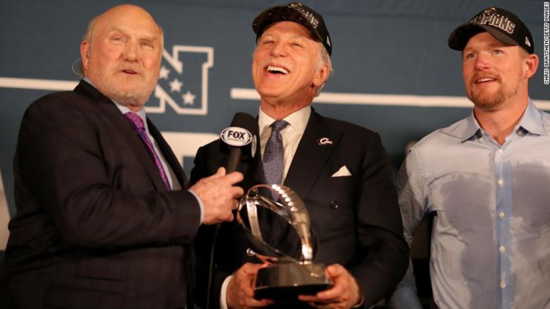 Terry Bradshaw presenta al propietario de los Rams, Stan Kroenke, con el trofeo de Campeonato de la NFC el 20 de enero.