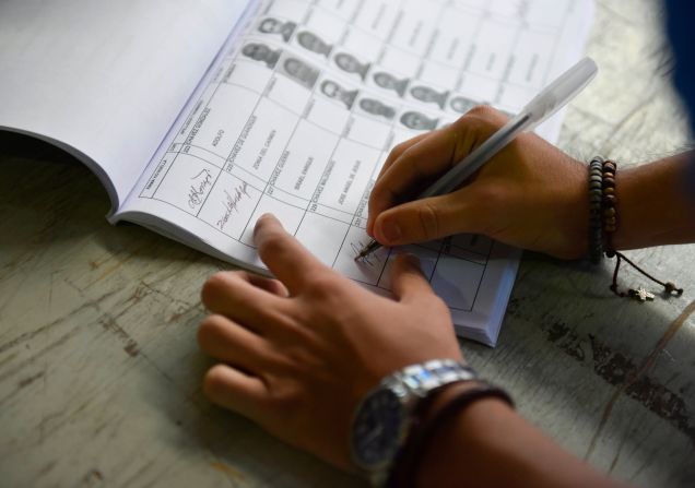 Un votante joven firma después de votar durante las elecciones presidenciales salvadoreñas en una mesa electoral en San Salvador, el 3 de febrero de 2019.