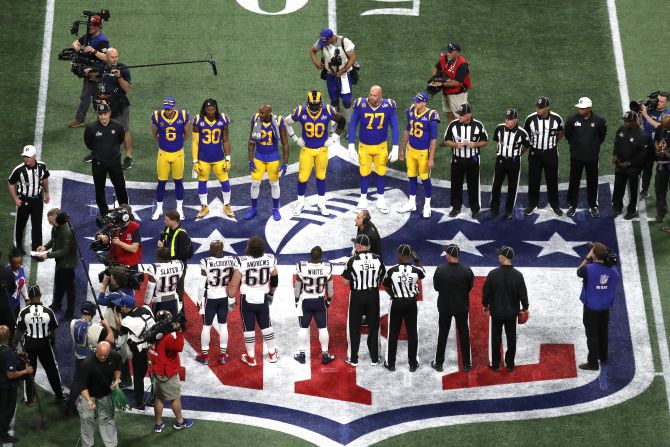 Ambos equipos se reúnen en el medio campo para el lanzamiento de la moneda antes del inicio del partido por el Super Bowl LIII, en el Mercedes-Benz Stadium.