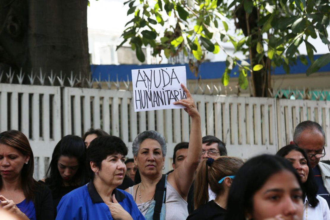 En una manifestación en Caracas, Venezuela, el 30 de enero de 2019, una mujer sostiene un cartel pidiendo ayuda humanitaria, en medio de la crisis económica, social y política del país suramericano.