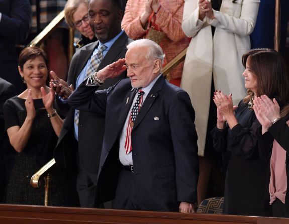 El exastronauta de la NASA Buzz Aldrin saluda cuando Trump lo reconoce durante su discurso. Trump agradeció al astronauta del Apolo 11 antes de decir "este año, los astronautas estadounidenses volverán al espacio en cohetes estadounidenses".