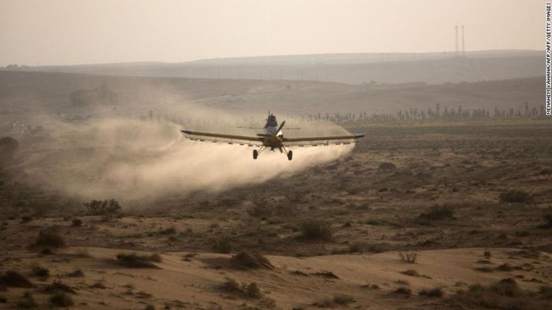 Un avión ligero esparce pesticida sobre una colina en el desierto de Negev cerca de la frontera de Egipto.