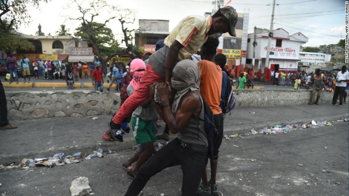 Los manifestantes intentan colocar una barricada durante los enfrentamientos con la policía haitiana en Puerto Príncipe el 15 de febrero.