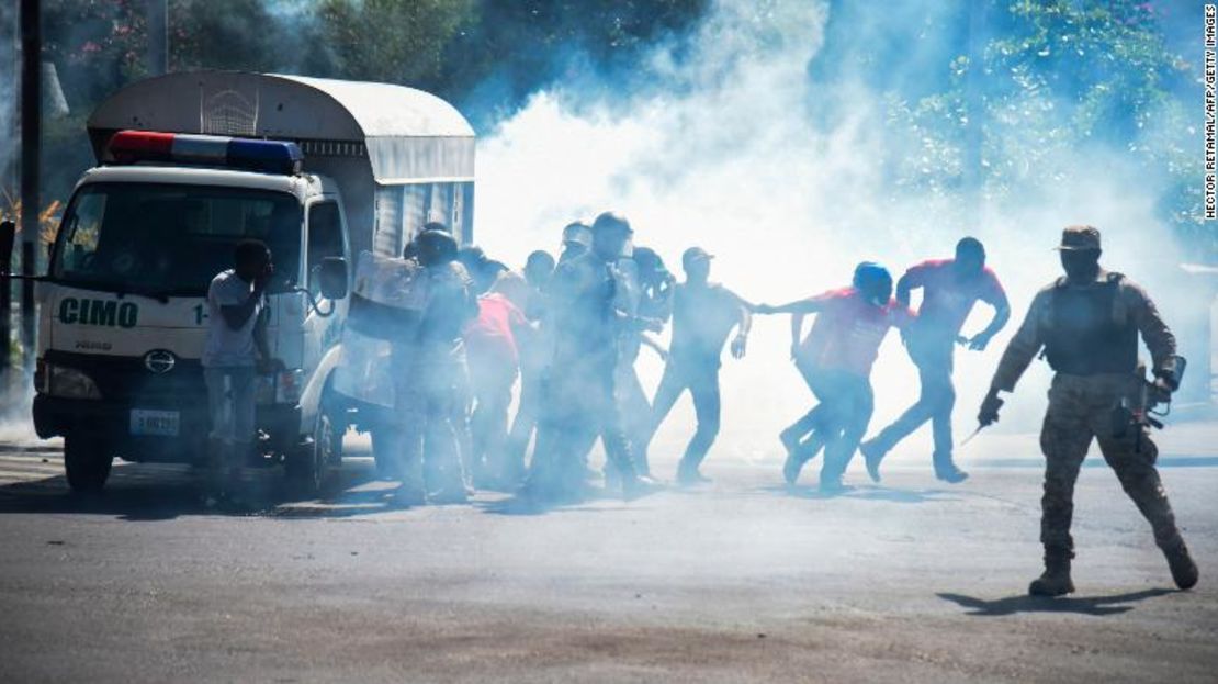 El pueblo haitiano huye de gases lacrimógenos en el centro de Puerto Príncipe, en el séptimo día de protestas contra el presidente haitiano Jovenel Moise.