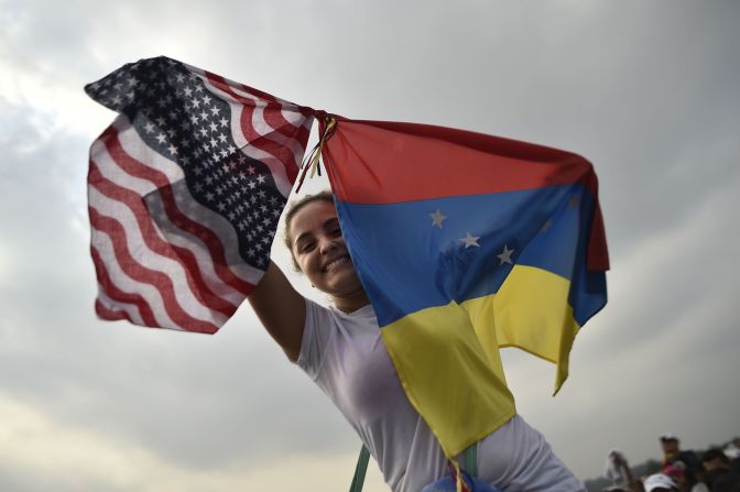 Una mujer sostiene la bandera de Venezuela y la de EE.UU. en el Venezuela Aid Live.