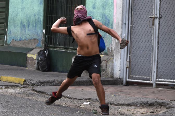 Un manifestantes arrojan piedras a la Guardia Nacional Bolivariana.