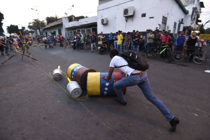 Un hombre empuja una barrera en Ureña en medio del bloqueo de los militares.