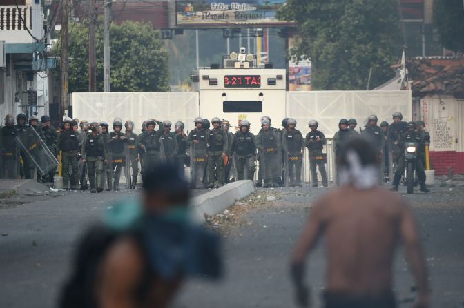 Una línea de guardias nacionales frente a manifestantes.